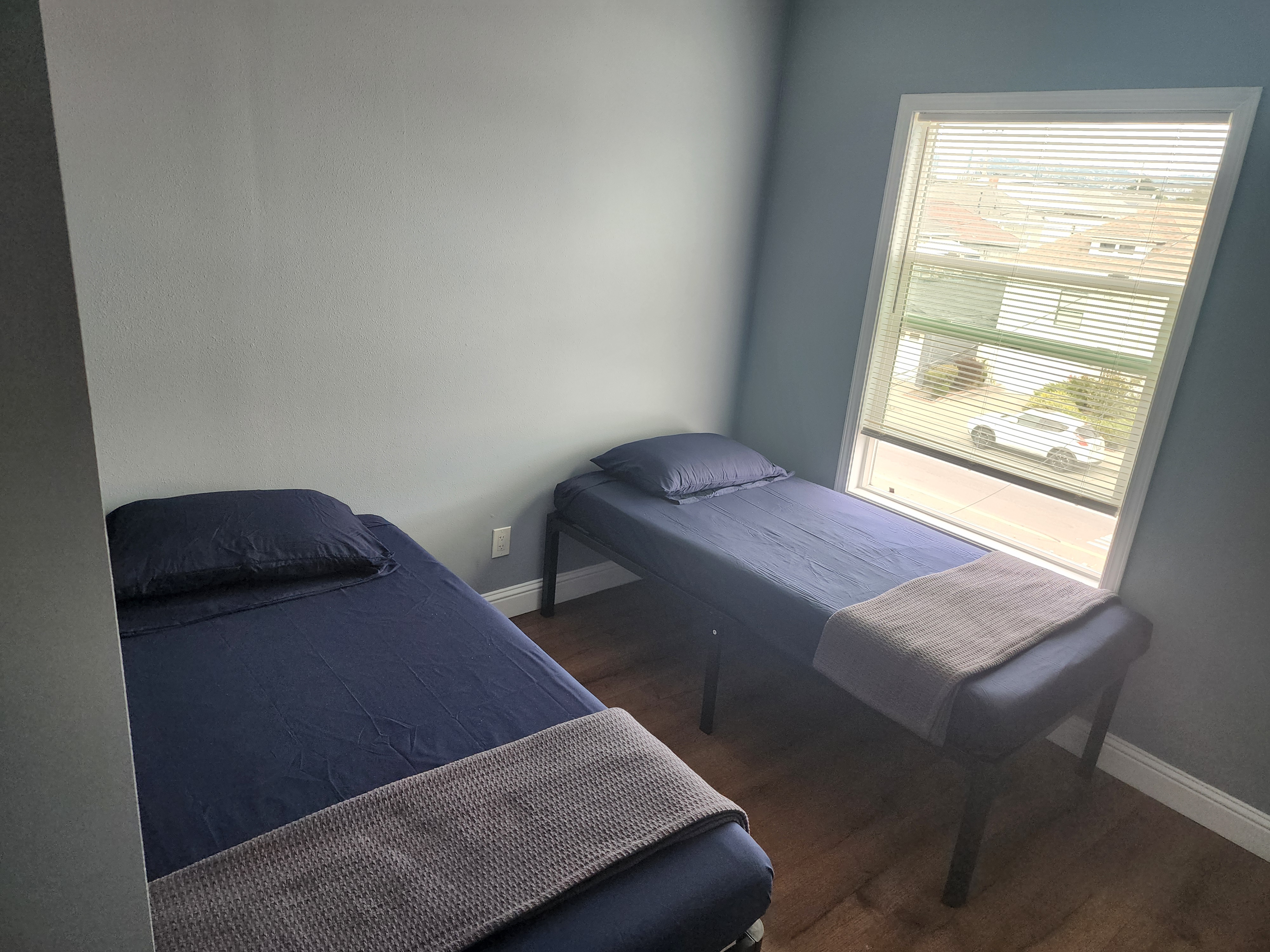 Bright shared bedroom with two twin beds beside a window