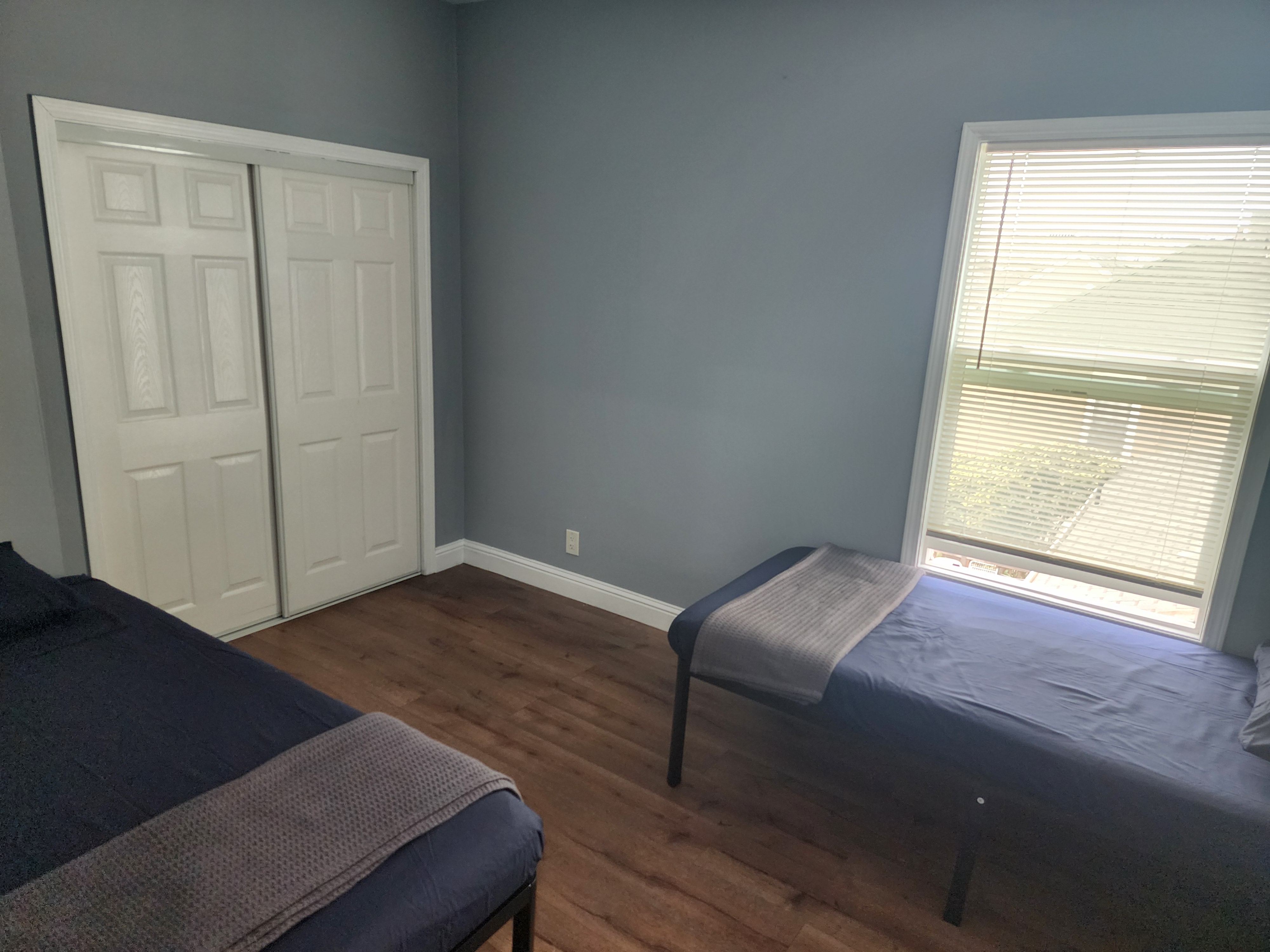 Shared bedroom with twin beds, closet, and wood flooring