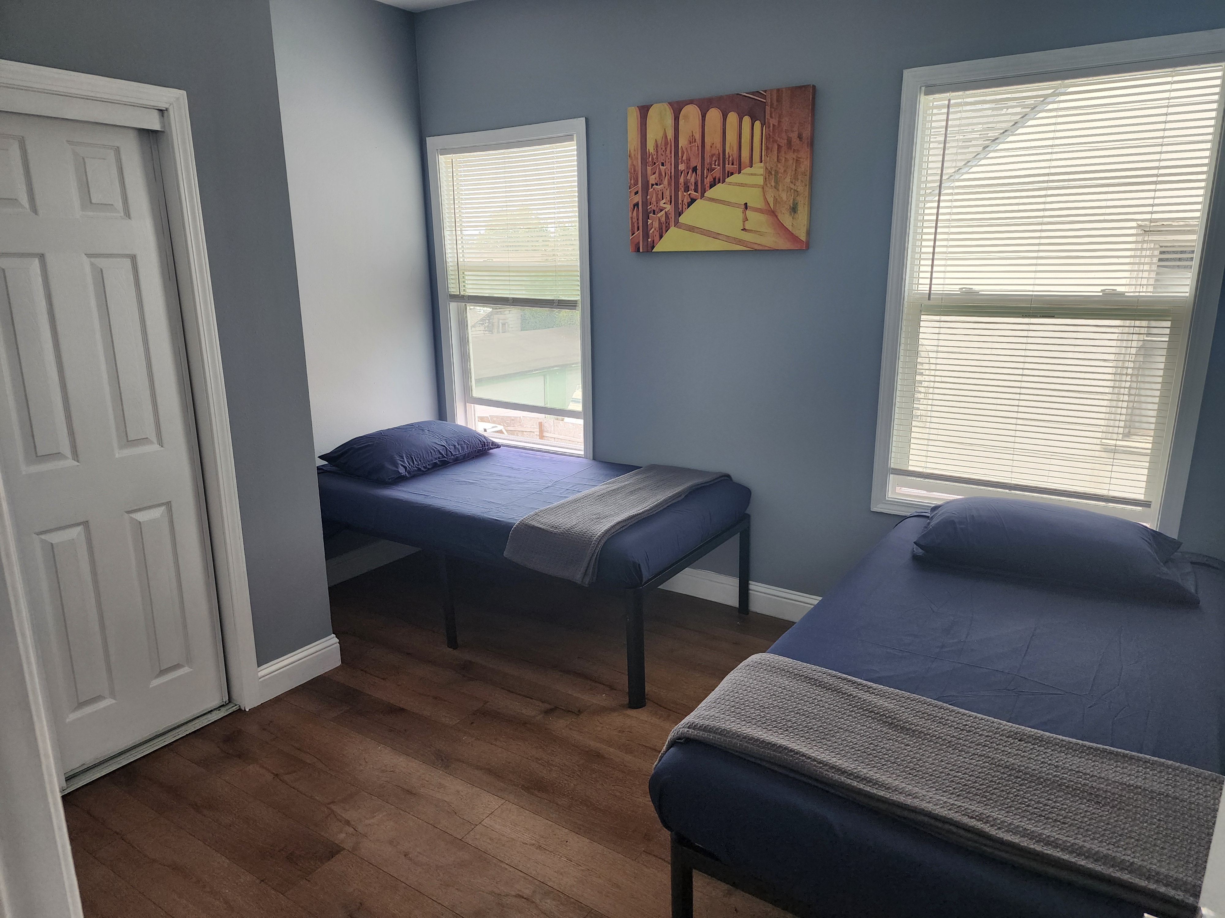 Shared bedroom with two neatly made twin beds and natural light